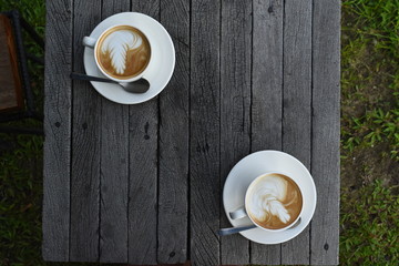 Close up a white coffee cup with heart shape on wood desk