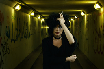 Fototapeta na wymiar Freaky woman with black hair smoking a cigarette