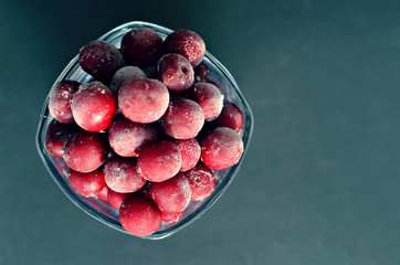 frozen cherry in a glass on a dark background, copy space 