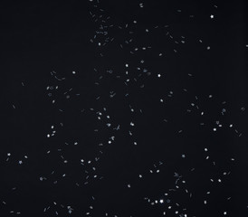 Lluvia de confeti de estrellas de color gris sobre fondo negro