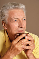 Close up portrait of senior man drinking cup of coffee