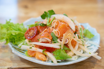  spicy mixed salad on wooden table.