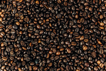 a lot of coffee beans on a wooden background. background and space for text