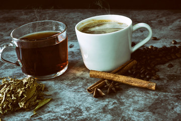 Hot coffee and hot tea with beans and tea leaves.