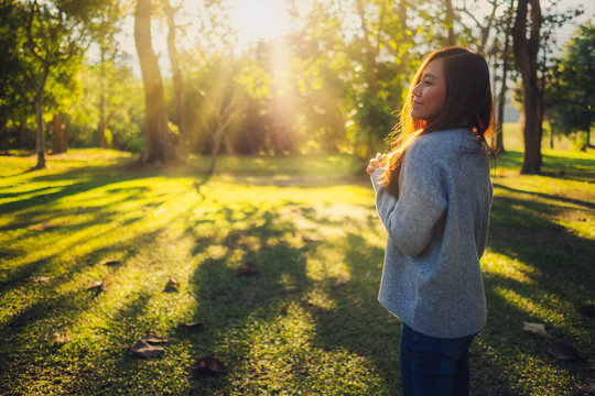 Portrait image of a beautiful asian woman standing among nature in the park before sunset