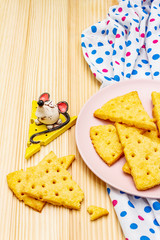 Funny kids cookies. Festive cheese crackers, New Year snack concept. Food, mouse sculpture, napkin. Wooden planks background