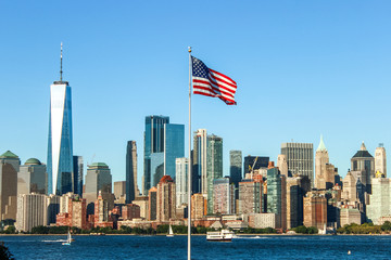 Panorama of the skyline of Manhattan with the American flag in the middle. One world trade center towering over the rest of the buildings. New York, USA.