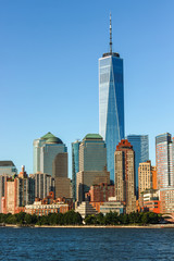 Skyline of Manhattan with the One world Trade Center towering over the rest of the buildings on a summer day, USA.