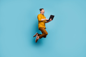 Full body photo of cheerful excited man jump use computer search online social media black friday...