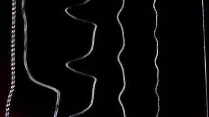 Acoustic guitar strings vibrating while playing music creating amazing patterns and soundwaves while strumming chords and single notes heavily on black background of the soundhole close up detail shot - Powered by Adobe