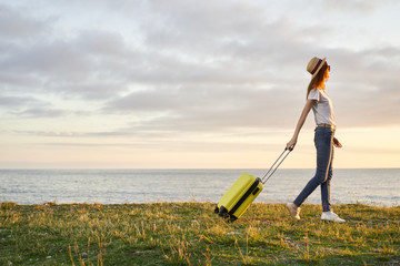 woman with suitcase on the beach