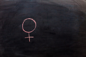 Fototapeta na wymiar Gender symbol of a woman on a chalkboard.