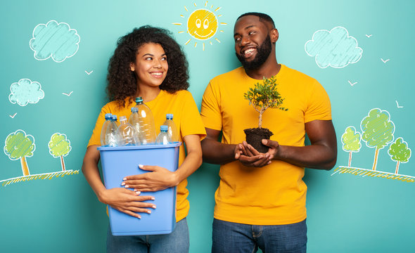 Happy couple hold a plastic container with bottles and a small tree over a light blue color. Concept of ecology, conservation, recycling and sustainability