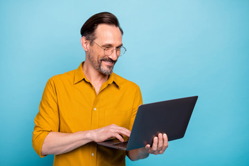 Portrait of positive man worker work on his computer text with his family colleagues wear yellow shirt isolated over blue color background - obrazy, fototapety, plakaty