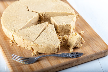 Sliced tahini halva on wooden bakcground.