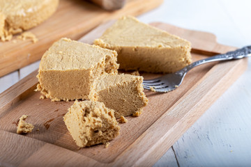 Sliced tahini halva on wooden bakcground.