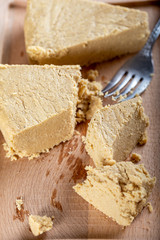 Sliced tahini halva on wooden bakcground.