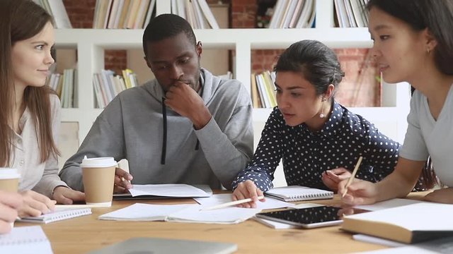 Concentrated mixed race friends working on research project.