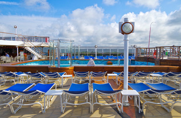 Mid Swimmingpool and Whirlpool on sun deck with sun beds loungers on Cunard luxury cruise ship...