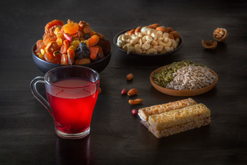Drink from a mix of dried fruits and bars of sports nutrition from nuts, honey, seeds on a dark table. low key. Close-up