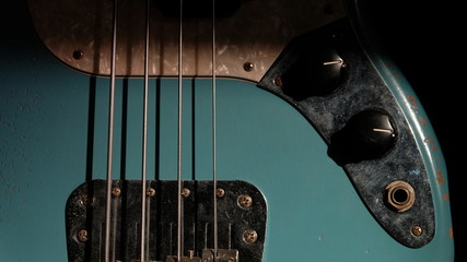 Closeup of Blue Guitar Bass and light coming through on Body Relic with selective focus.
