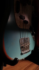 Closeup of Blue Guitar Bass and light coming through on Body Relic with selective focus.