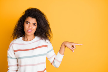 Closeup photo portrait of unhappy sad upset expressing disgust girl showing pointing finger to copy space isolated bright color background - obrazy, fototapety, plakaty
