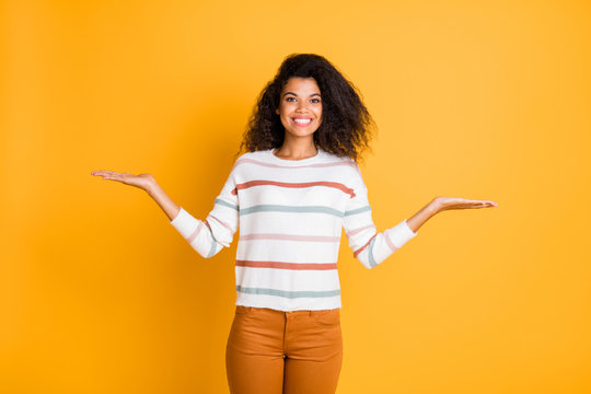 Portrait of her she nice attractive lovely cheerful cheery glad content wavy-haired girl holding on palms two invisible objects isolated over bright vivid shine vibrant yellow color background