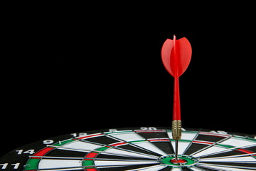 dartboard and dart on a black background with copy space
