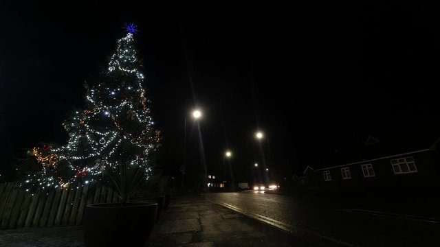 Christmas tree fairy lights speeding night traffic timelapse countdown rushing concept. Low angle/
