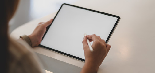 Cropped shot of businesswoman working on her project with blank screen tablet