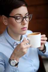 Close-up of a beautiful woman with a Cup of coffee in a cafe.