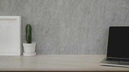 Cropped shot of stylish workplace with copy space and office supplies on marble desk and grey wall