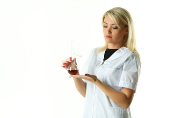 female lab technician in a white coat holding a flask with a reagent