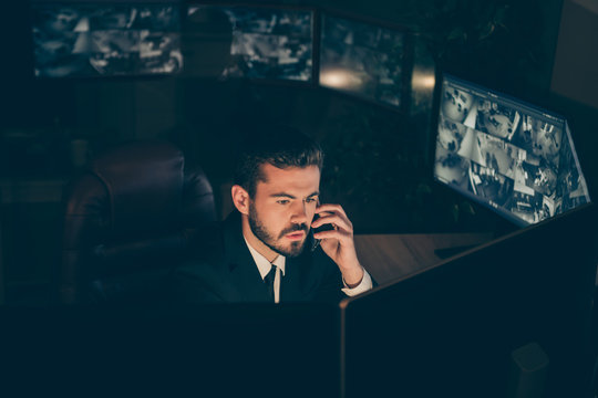 Portrait of his he nice attractive serious safety private property specialist supervising remote IT tech panel night shift calling employer providing online web information at workplace workstation