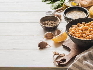 Set of ingredients for cooking homemade traditional hummus on a white wood background. Copy space