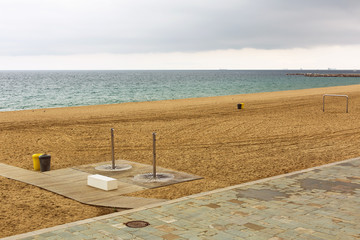 Modern shower on an empty sandy beach. Concept of no tourist season.