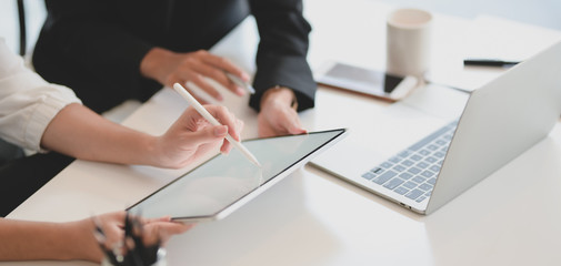 Cropped shot of young businesswoman explaining her idea to her coworker with blank screen tablet
