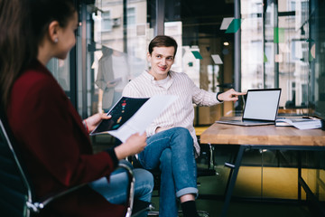 Obraz premium Szczęśliwy przedsiębiorca pokazuje klientowi ekran laptopa