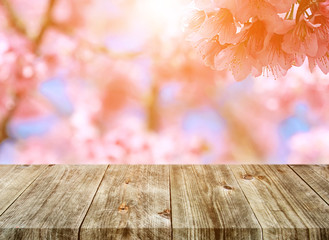 Naklejka na ściany i meble Old brown wooden plank with blurred pink flower nature backgrounds