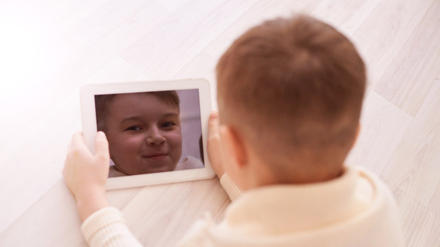 Cute boy. Face on screen. Light background. Horizontal