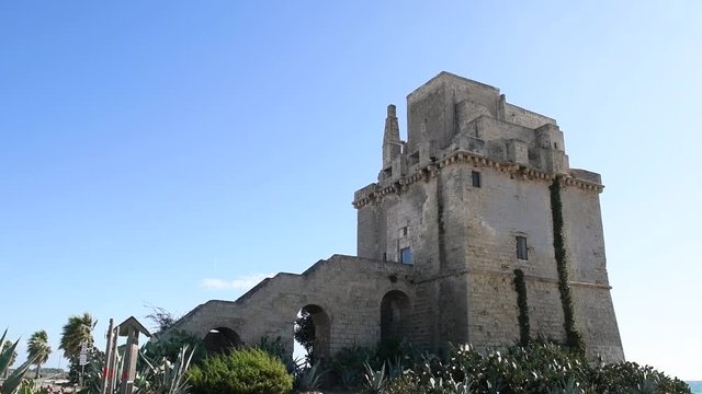 Panoramic view of Torre colimena's fortified tower. An ancient fortified tower in a summer seaside landscape of a touristic resort in Puglia, Italy. Historical monument of Torre Colimena's port