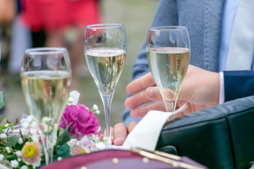 hands of man holding a glass of champagne to celebrated for special occasion together between friends and family, for Christmas' Eve, New year party.  