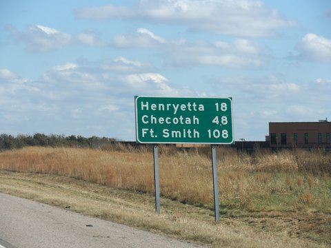 Roadside sign with distances to Henryetta, Chekotah and Fort Smith at Interstate 240 in Oklahoma.