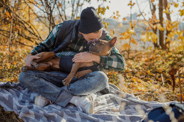 Fototapeta premium Man kissing the dog and putting glasses on him stock photo