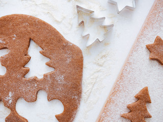 Christmas and New Year bakery. Cooking traditional gingerbread cookies. backround White table . Wooden plank Top view. Christmas baking background: dough, cookie cutters