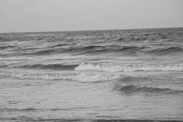 black and white photo of sea or beach water in the evening at chennai marina beach with some waves
