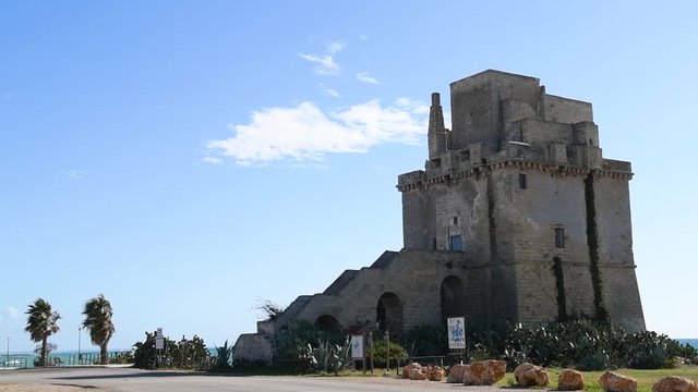 Panoramic view of Torre colimena'sfortified tower. An ancient fortified tower in a summer seaside landscape of a touristic resort in Puglia, Italy. Historical monument of Torre Сolimena's port