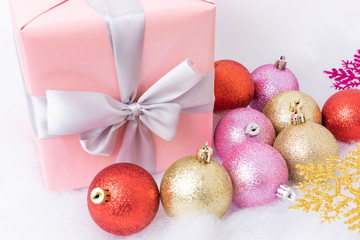 Christmas gifts and balls on snow background