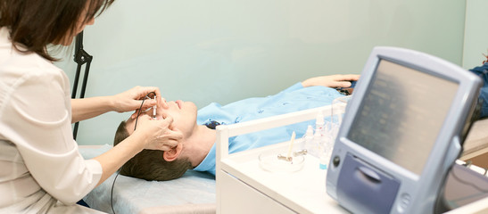 ophthalmologist doctor in exam optician laboratory with male patient. Men eye care medical diagnostic. Eyelid treatment